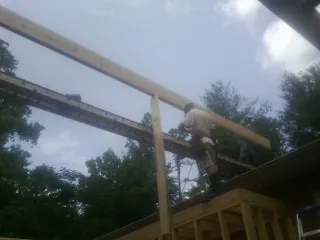 Carpenter setting a ridge beam over a new addition frame — Ice Dam Removal by Roofing Brothers in Raymore